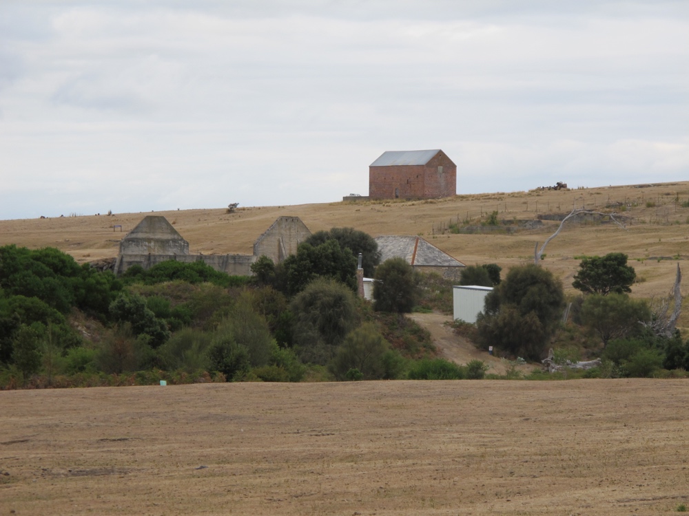 More old buildings, and dry grass.